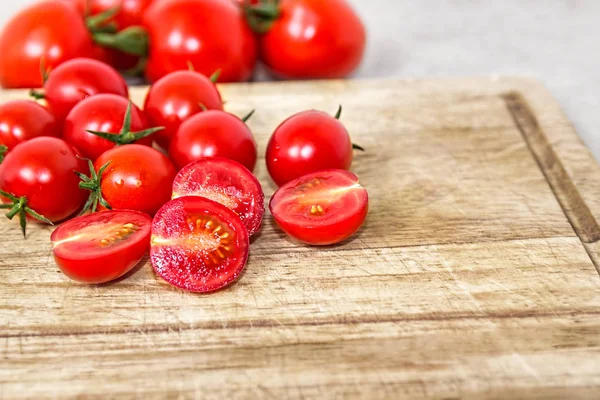 Tomates cereja em uma tábua de corte de madeira. Fundo vegetal. Produtos biológicos . — Fotografia de Stock