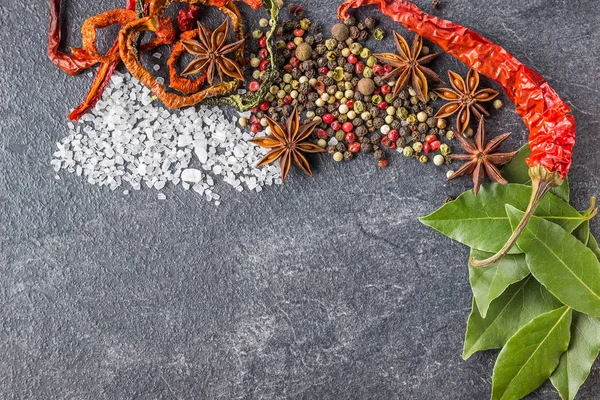 Gewürze auf steinschwarzem Hintergrund. Gewürze auf einem dunklen Tisch — Stockfoto