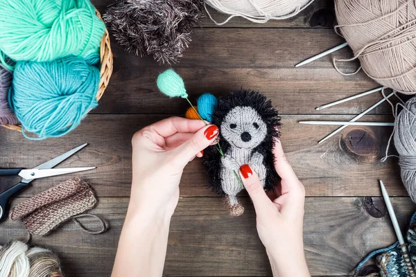 Knitted Hedgehog with balloons, Gifts handmade. Knitting on Wooden background. Making knitted toys — Stock Photo, Image