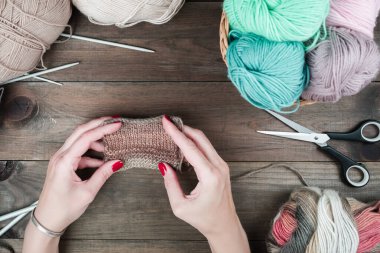 Örgü ören ellerin yakın çekimi. Renkli iplikler. Renkli iplik yünü seçimi. Örgü arka planı. El yapımı kışlık elbiseler için iplik örüyorum..