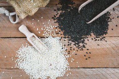 Farklı susam tohumları. Beyaz ve siyah susam tohumları. Ahşap arka planda mevsimler