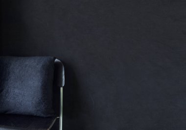 Siyah iç kısımda siyah bar taburesi üzerine siyah yastık. Yatay yakın çekim ve yatak odasının önü. Duvarında da fotokopi alanı var. En az koyu arkaplan.