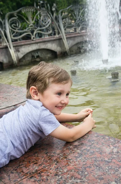 Liten pojke vid fontänen — Stockfoto