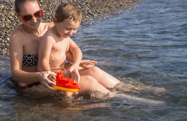 Mutter und Sohn spielen mit Schiff — Stockfoto