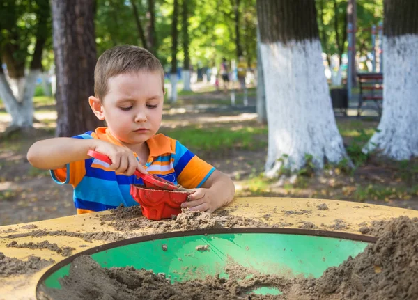 Четырехлетний мальчик на детской площадке в городском парке — стоковое фото