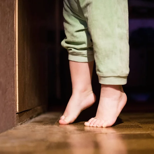 Baby bare feet in front of closed door — Stock Photo, Image