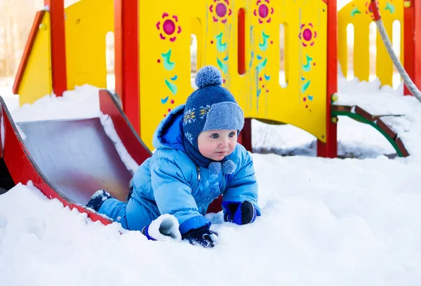 Мальчик на детской площадке зимой — стоковое фото