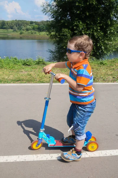 Menino montando uma scooter — Fotografia de Stock