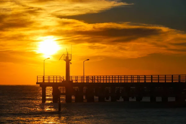 Sunny sunset genom piren vid havet — Stockfoto