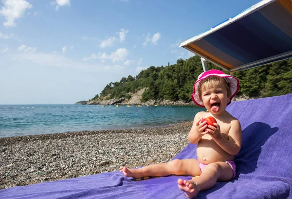 Menina criança com pêssego em cadeira de praia por mar — Fotografia de Stock
