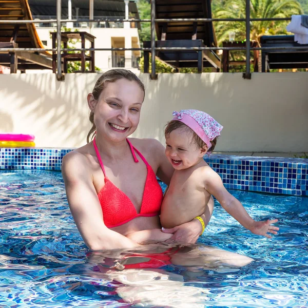 Örömteli anya a kislányom, fürdőzés a medencében — Stock Fotó
