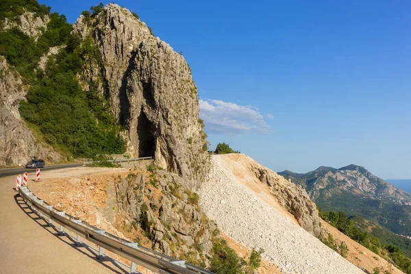 Mountain winding road passes through rock — Stock Photo, Image