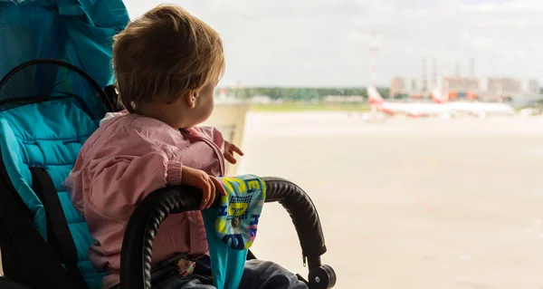 Малышка смотрит в окно аэропорта — стоковое фото