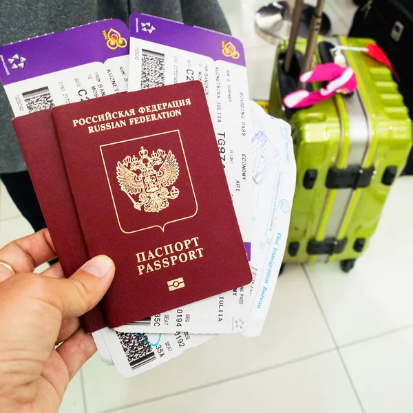 Hand met paspoorten en vliegtickets tegen de achtergrond van su Rechtenvrije Stockfoto's