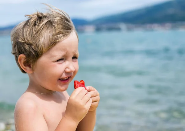 Menino come morangos com prazer — Fotografia de Stock