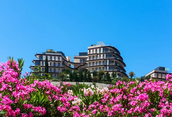 Hotel bouwen tussen bloemen en groen tegen blauwe hemel Stockfoto