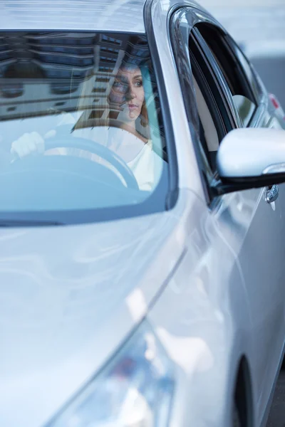Jovem mulher loira adulta dirigindo um carro — Fotografia de Stock