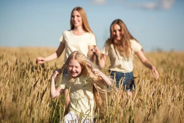 Matka a daugthers běží na pšenici podané — Stock fotografie