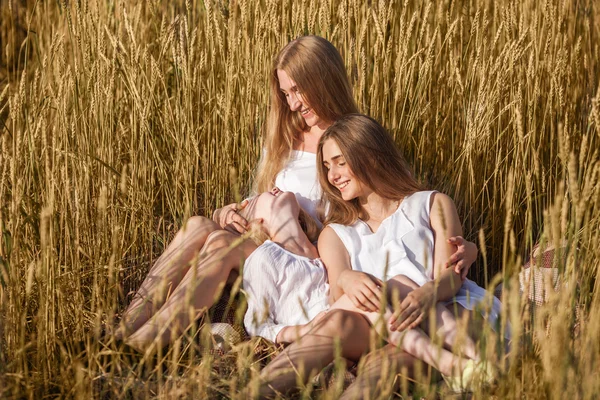 Krásná mladá matka a její dcery v pšeničné pole — Stock fotografie