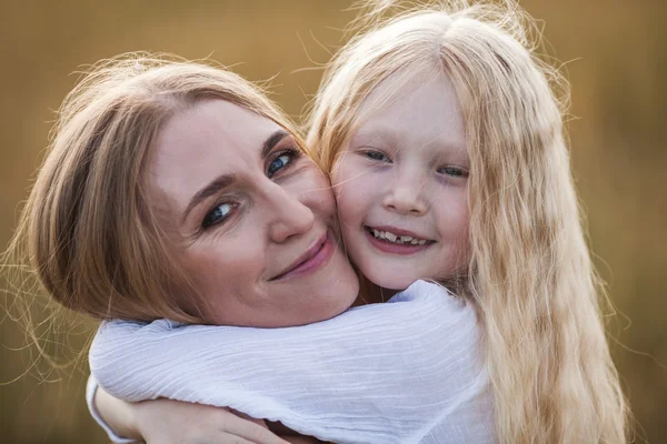 Mooie jonge moeder en haar dochter op het tarweveld — Stockfoto