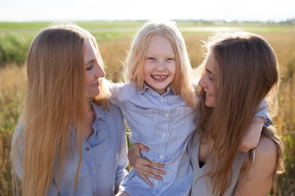 Beautiful young mother and her daughters at the wheat field — Stock Photo, Image