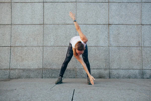 Sportiga kvinnan göra stretchingövningar — Stockfoto