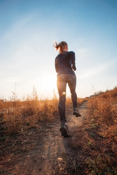 Woman running outdoors at sunset — Stock Photo, Image