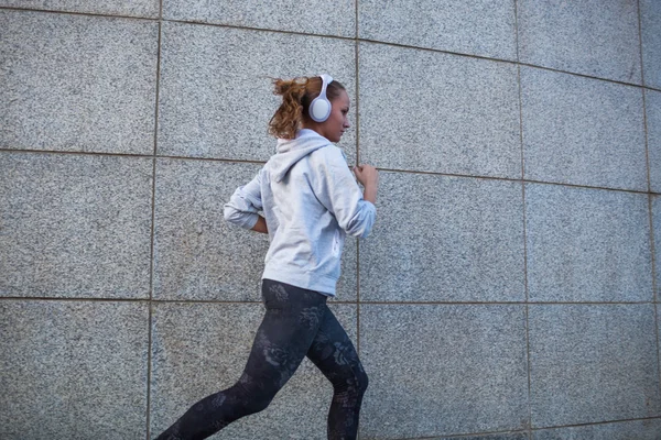 Ung kvinna som springer i staden — Stockfoto