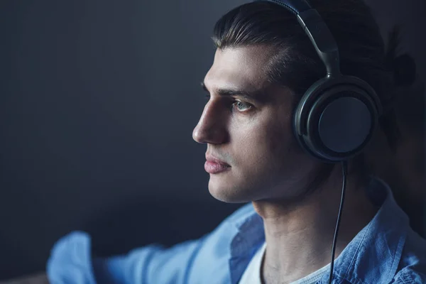 Música na mente dele. Retrato de jovem vestindo fones de ouvido e olhando para longe — Fotografia de Stock