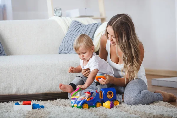 かわいいお母さんと子供の男の子が家で屋内で遊ぶ — ストック写真