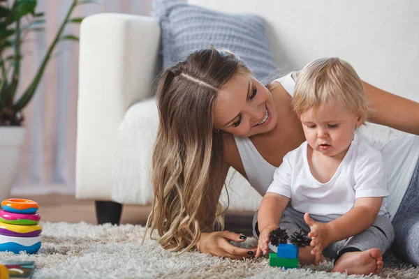 Bonito mãe e criança menino jogar juntos dentro de casa — Fotografia de Stock