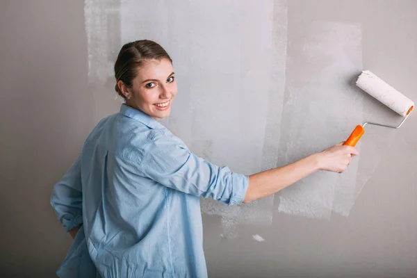 Beautiful young woman doing wall painting — Stock Photo, Image