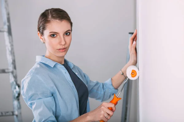 Beautiful young woman doing wall painting — Stock Photo, Image