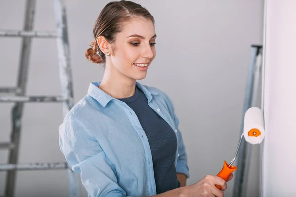 Beautiful young woman doing wall painting — Stock Photo, Image