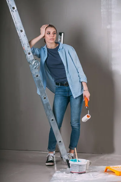 Tired woman at work in the home - painting wall at room — Stock Photo, Image