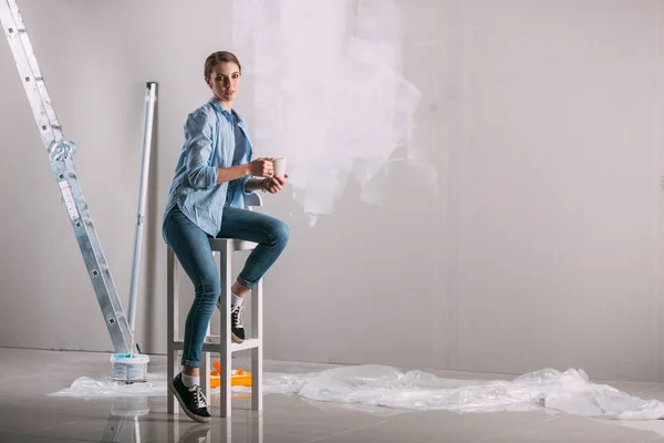 Tired woman at work in the home - painting wall at room — Stock Photo, Image