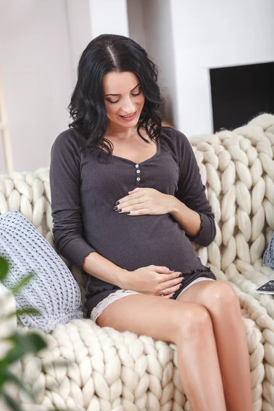 Ευτυχής όμορφη έγκυος γυναίκα χαλαρώνοντας στον καναπέ — Φωτογραφία Αρχείου