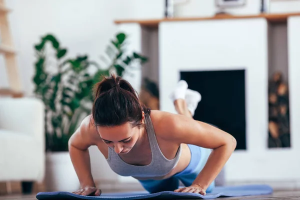 Mujeres ejercicio interior en casa ella es actuado flexiones —  Fotos de Stock