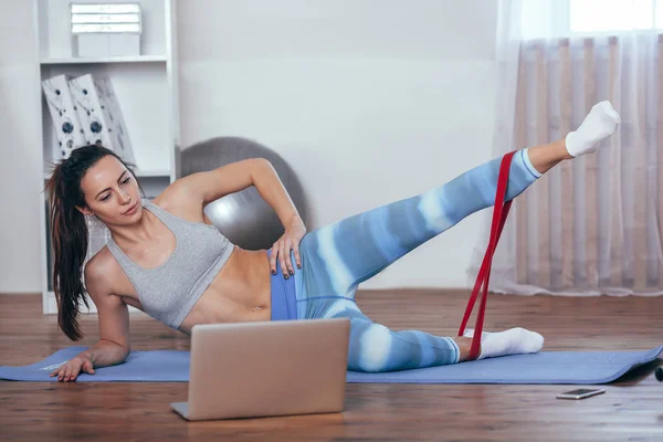 Sporty athletic woman exercising with rubber tape — Stock Photo, Image