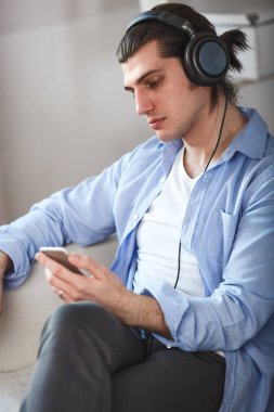 Yakışıklı adam smartphone ile internet üzerinden müzik dinlemek