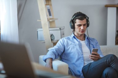 Yakışıklı adam smartphone ile internet üzerinden müzik dinlemek