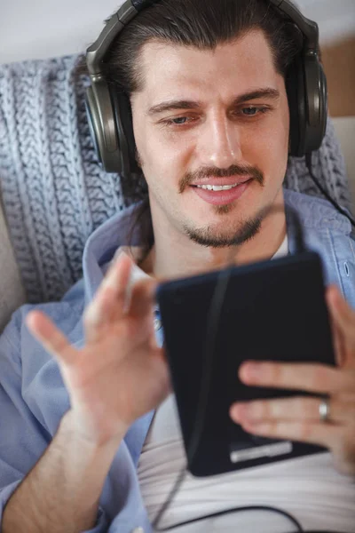 Beau gars écouter de la musique sur Internet avec tablette — Photo