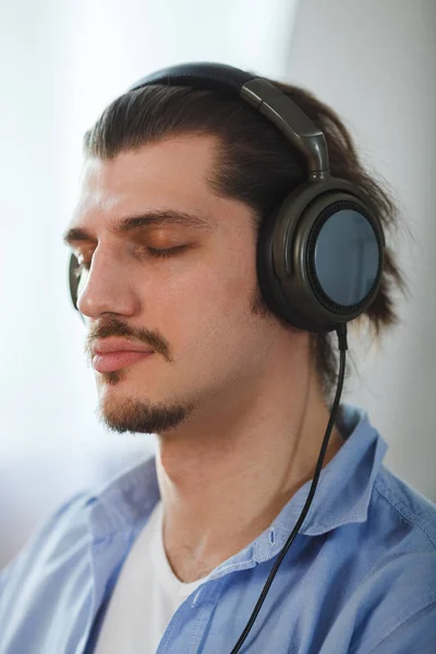 Música na mente dele. Retrato de jovem vestindo fones de ouvido e olhos fechados — Fotografia de Stock