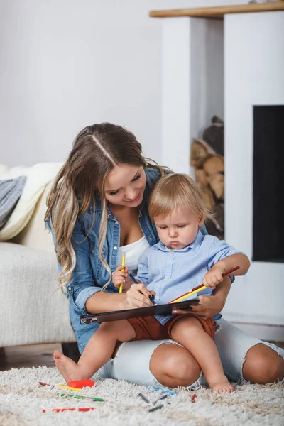 Mãe e filho pintam as paredes e o chão. Criatividade infantil . — Fotografia de Stock