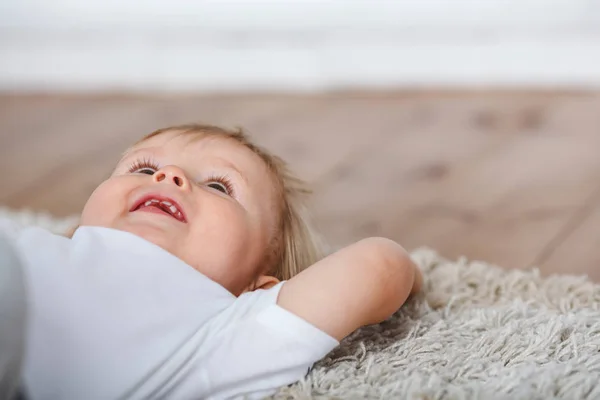 Niedlicher kleiner Junge liegt auf Teppichboden — Stockfoto