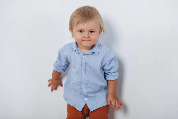 Portret van lachende schattige kleine jongen in de buurt van witte muur — Stockfoto