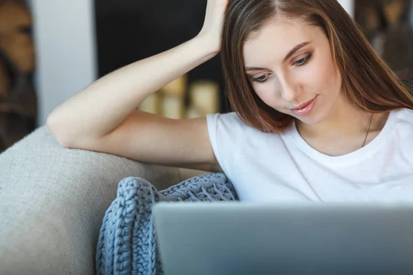 Jonge vrouw zitten met laptop op de Bank bij haar thuis — Stockfoto