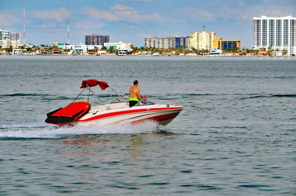 赤距離でノース マイアミ ビーチの高級コンドミニアムの建物とマイアミ ビーチ フロリダ内沿岸水路のレーシング トリムとなめらかな白いモーター ボート — ストック写真