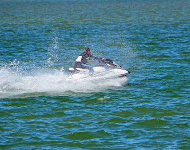 Florida içi kıyı suyolu Miami Beach kapalı bir jet ski üzerinde hızlandırmak bir wetsuit giyen adam.
