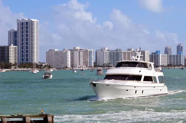 Luxury motor yacht on the florida intra-coastal waterway with Southbeach condo skyline in the backkground.